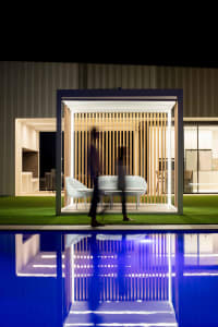 An outdoor garden retreat featuring a minimalist design with a wooden terrace.