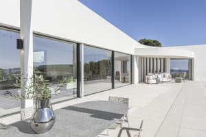 Modern residential patio featuring glass walls and concrete flooring.