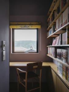 A minimalist bookshelf made of wood with books and shelves arranged neatly on shelves.