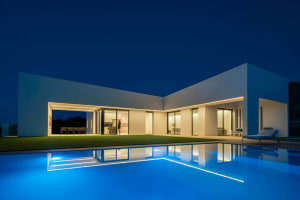 A modern residential home featuring concrete and glass materials.