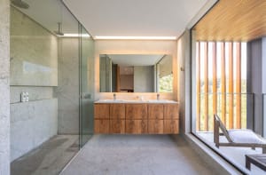Modern bathroom with concrete walls, minimalist furniture, and large windows