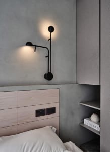 Minimalist bedroom featuring industrial-style lighting and wooden headboard.