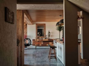 Modern industrial kitchen featuring wooden countertops with a mix of natural textures, including concrete walls and floors, a