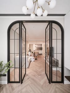 A minimalist living room with wooden furniture and glass doors.
