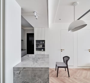A modern, minimalist residential kitchen with a marble countertop.