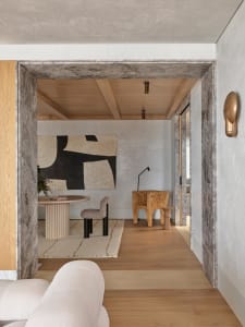 A modern dining room featuring wood flooring, a round table, and abstract art on the wall.