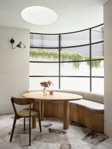 A minimalist interior with a wooden table and marble floor.