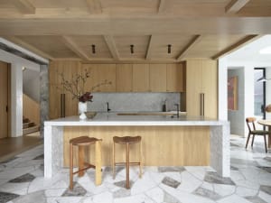 A modern kitchen featuring wooden cabinets and marble countertops.