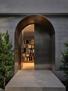 An arched metallic entranceway leading into a space filled with books.