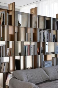 Modern living room featuring a metal sculpture shelf displaying books and decorative items.