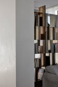 Modern library or study room featuring a metal and glass shelving unit