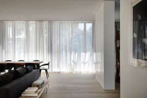 A modern living space featuring transparent curtains.