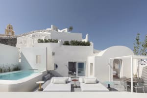 A white, plaster-residential building with a pool and outdoor space.
