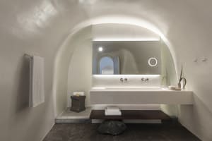 A modern bathroom featuring white stone surfaces and minimalistic design.