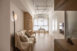 Minimalist living space featuring wooden furniture and flooring.