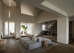 A minimalist living room featuring concrete surfaces and a modern design.