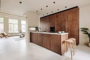 A modern kitchen featuring wooden cabinets and white flooring.
