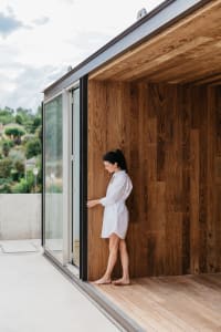 A modern exterior space featuring wooden flooring and a wooden wall.