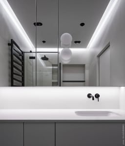 A modern minimalist white bathroom with sleek lines and a neutral color palette.