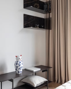 A minimalist bedroom featuring glass and marble decor elements.