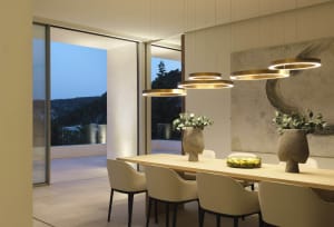 Modern residential dining room featuring wood elements and contemporary lighting.