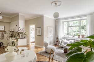 Modern, minimalist living room with neutral-colored furnishings, white walls, and a cozy sofa.