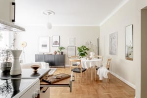 A modern, minimalist interior featuring a wooden floor, metal accents, and glass elements.