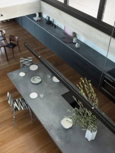 A modern, industrial kitchen with concrete countertops and minimalist decor.