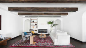 White living room with wood flooring, minimalist decor, and a cozy fireplace.