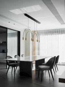 Modern dining room with marble table and black furniture.