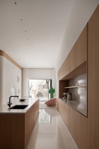 Modern kitchen featuring wooden cabinets, sleek countertops, and a black faucet.