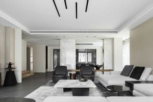 Modern living room featuring marble accents, wooden furniture, and leather chairs.