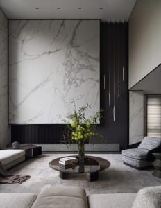Modern living room featuring marble walls and a round coffee table with a greenery arrangement.