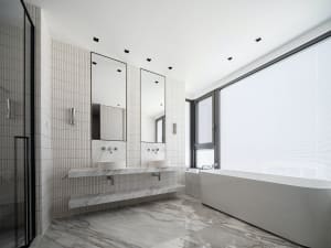 Modern minimalist bathroom with marble finishes and a large window.