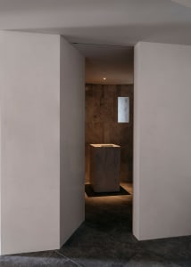A minimalist interior space with a marble object in the center.