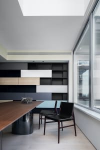 A modern office space featuring wooden furniture, glass walls, and metallic accents.