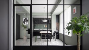 A modern kitchen and dining area with a table and chairs, modern lighting, and mixed materials.