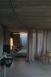 Modern minimalist residential interior with concrete, glass, and wood materials.