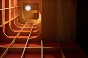 Image of an indoor space with curved wooden shelves and steps.