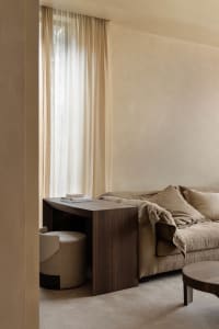 A minimalist living room with neutral-toned furniture and decor.