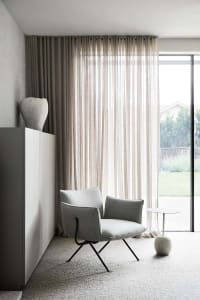 Modern living room featuring gray furniture, lighting, and concrete elements.