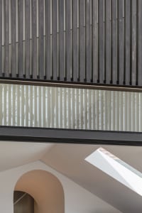 Industrial-style interior with metal and glass architectural elements and a curved archway.