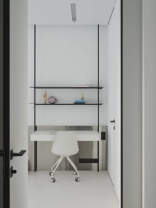 A minimalist white desk with a black metal frame in a minimalist environment.