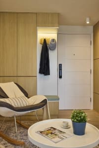 Modern entrance area featuring a wooden bench, coat rack, and door with a digital lock.