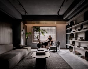 A modern living room featuring a minimalist design with concrete and metal elements.