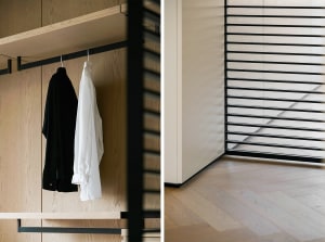 A modern closet with wooden shelves and black metal rods.