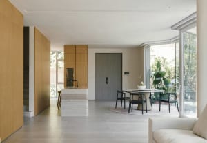 A modern residential living space featuring a kitchen island with marble countertops, a dining area with a round table and ch