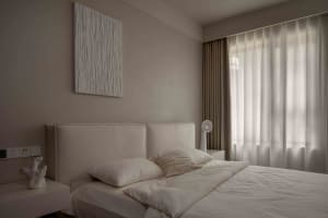 Modern minimalist bedroom with a fabric headboard and white bedding.