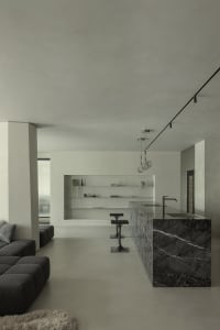 A minimalist kitchen with a marble countertop and island.