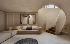 A modern living room with a concrete floor, minimalist decor, and a large sectional sofa.